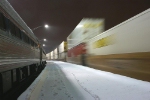 NS train 214's containers are a blur as they pass the parked Lynchburg NEC Regional train